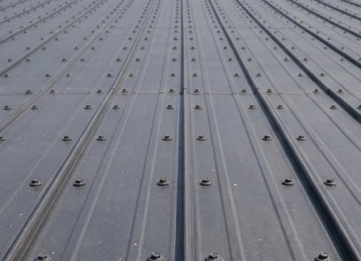 Ribbed exposed fastener metal roofing panels